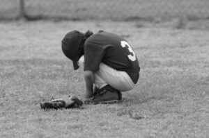 kid boy kneeling field sad